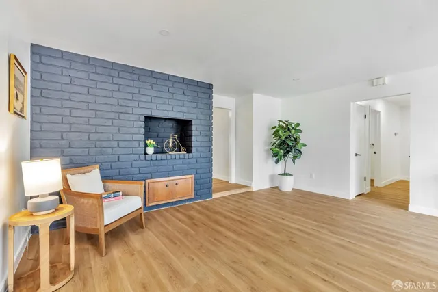 a living room with a wooden floor and potted plant