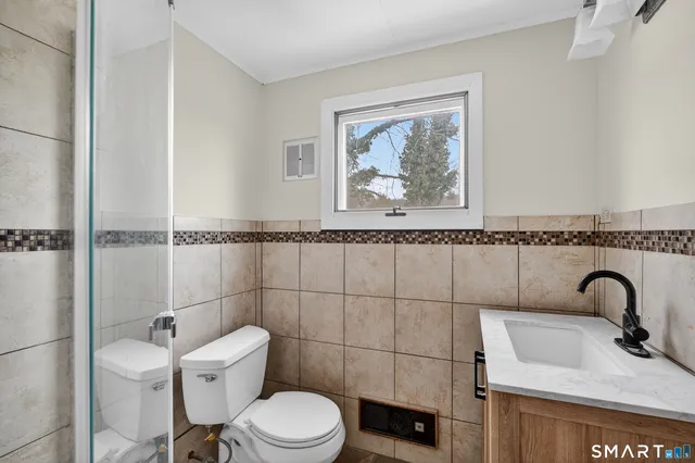 a bathroom with a toilet sink vanity and tub