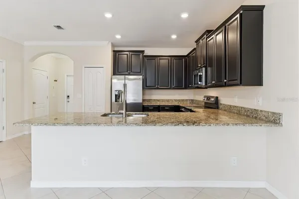a kitchen with stainless steel appliances granite countertop a sink a stove and a refrigerator