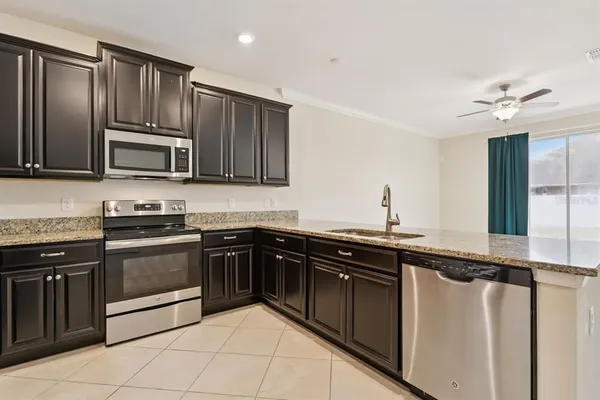 a kitchen with granite countertop stainless steel appliances and wooden cabinets