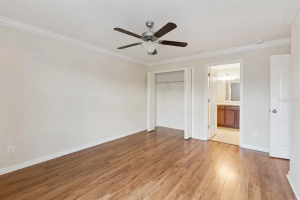 a view of a big room with wooden floor and a ceiling fan