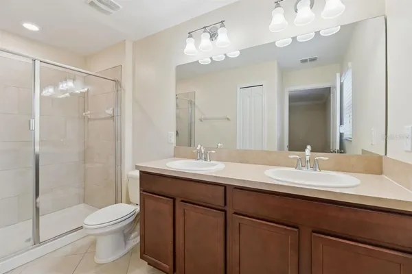 a bathroom with a granite countertop sink a toilet and a mirror