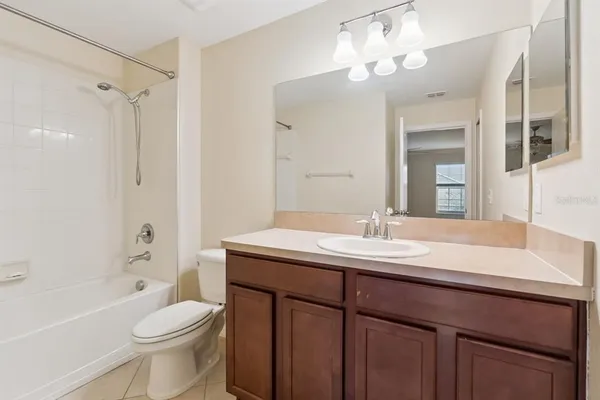 a bathroom with a granite countertop sink toilet a large mirror a bathtub and shower