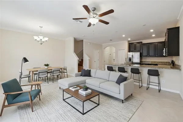 a living room with furniture and a view of kitchen