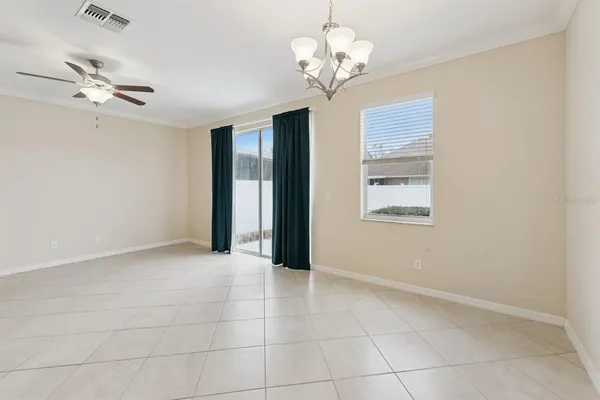 a view of an empty room with a chandelier fan