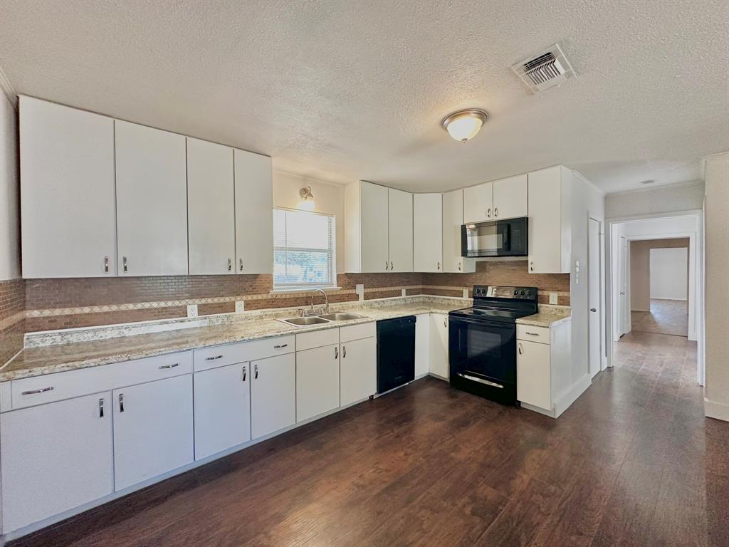 161 Elizabeth Street, Unit A Pottsboro, TX 75076 - Photo 1 of 20 a kitchen with granite countertop white cabinets and stainless steel appliances