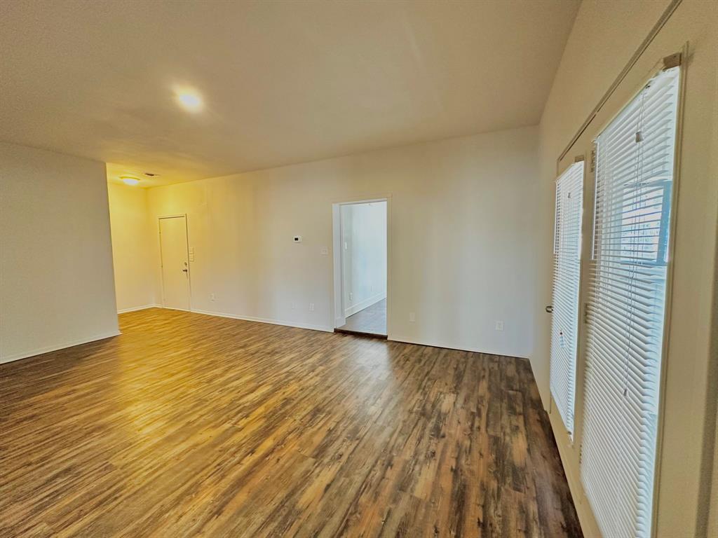 161 Elizabeth Street, Unit A Pottsboro, TX 75076 - Photo 11 of 20 a view of empty room with wooden floor and fan