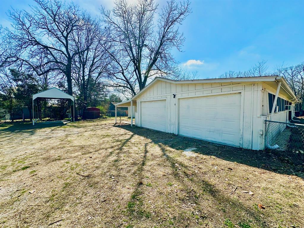 161 Elizabeth Street, Unit A Pottsboro, TX 75076 - Photo 18 of 20 a backyard of a house with large trees and covered with wooden fence
