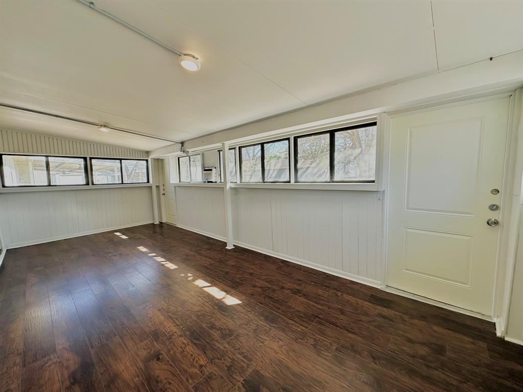 161 Elizabeth Street, Unit A Pottsboro, TX 75076 - Photo 5 of 20 an empty room with wooden floor and windows