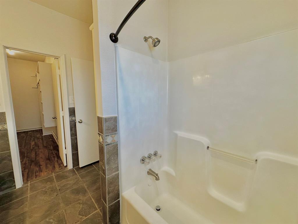 161 Elizabeth Street, Unit A Pottsboro, TX 75076 - Photo 7 of 20 a bathroom with a bathtub and a shower