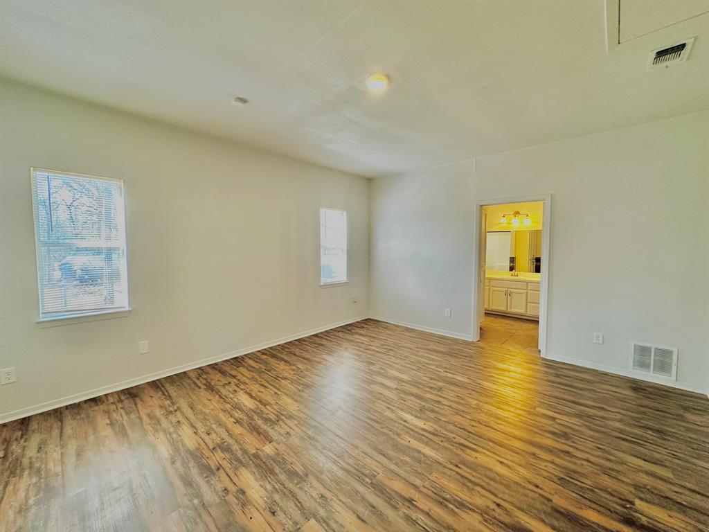 161 Elizabeth Street, Unit A Pottsboro, TX 75076 - Photo 8 of 20 a view of empty room with wooden floor and fan