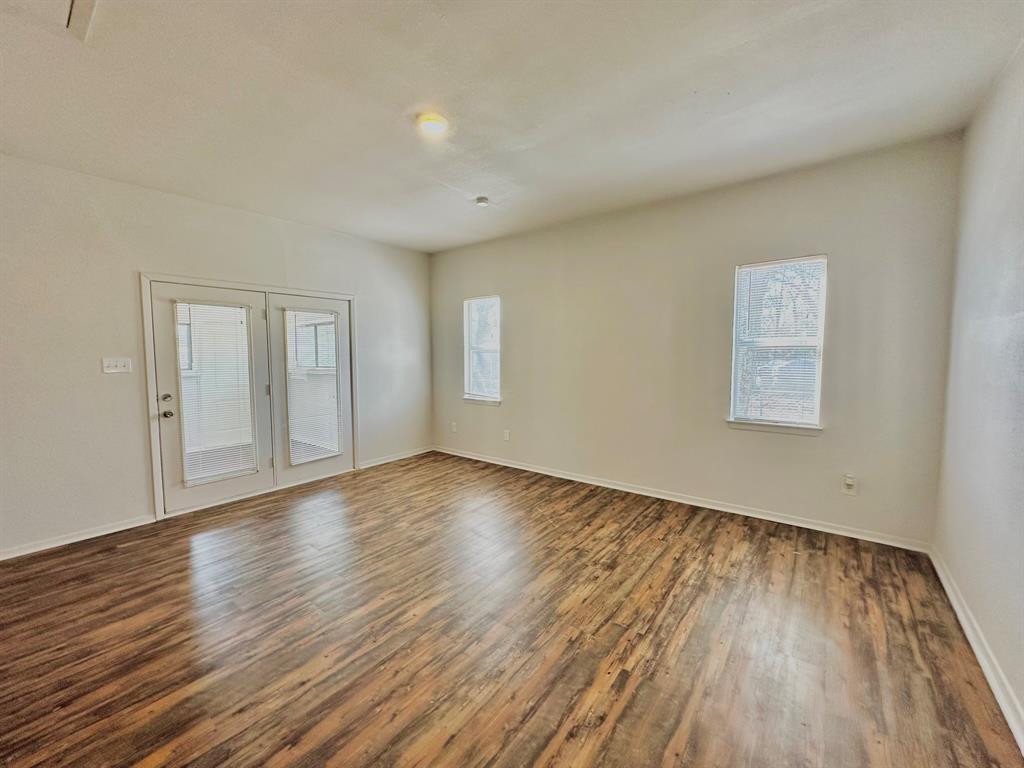 161 Elizabeth Street, Unit A Pottsboro, TX 75076 - Photo 9 of 20 a view of empty room with wooden floor and fan