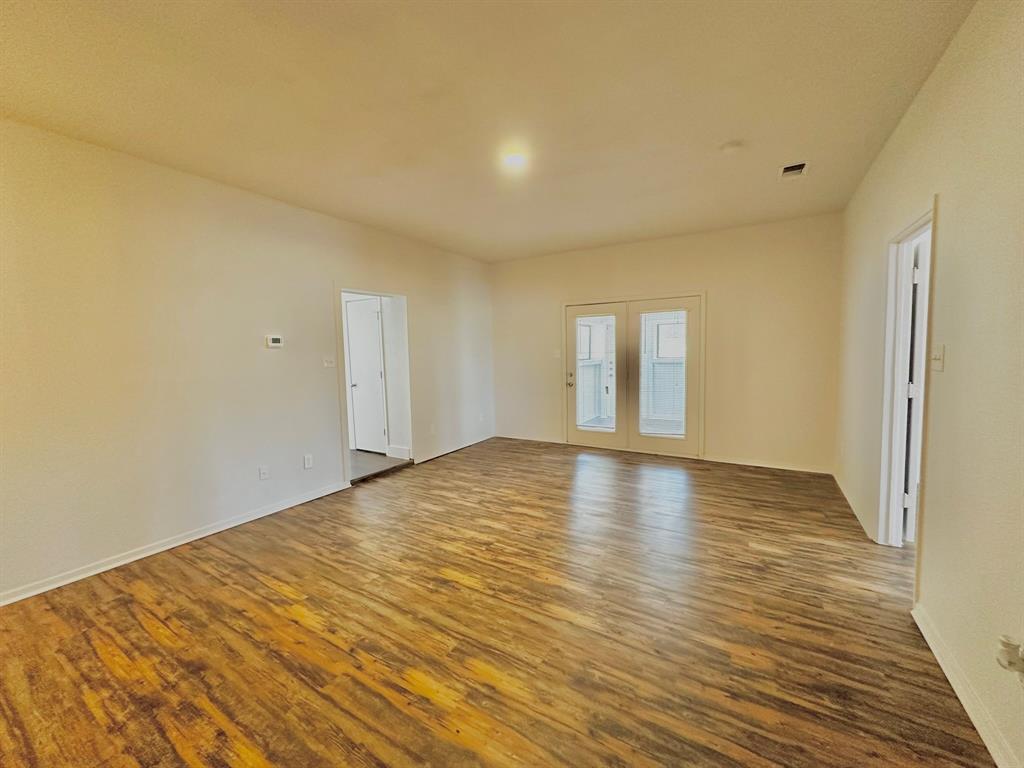 161 Elizabeth Street, Unit A Pottsboro, TX 75076 - Photo 10 of 20 a view of empty room with wooden floor and fan