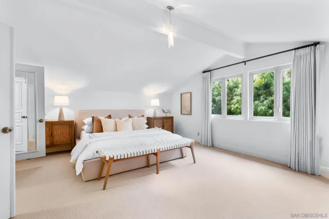 a spacious bedroom with a bed and a large window