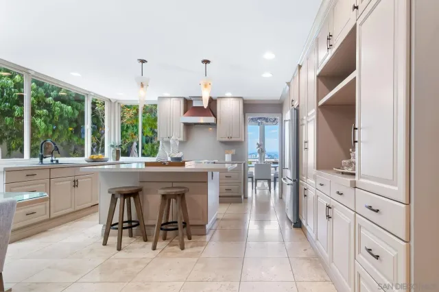 a kitchen with stainless steel appliances a table and chairs in it