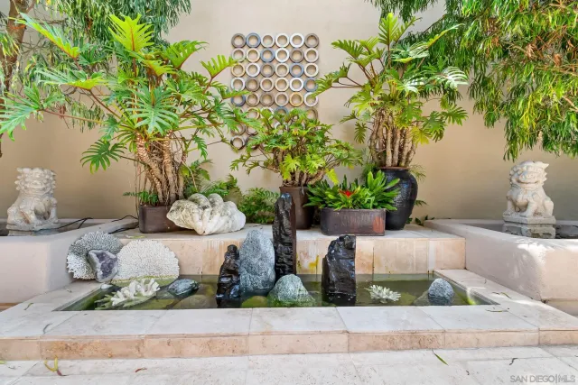 a front view of a house with a yard and fountain