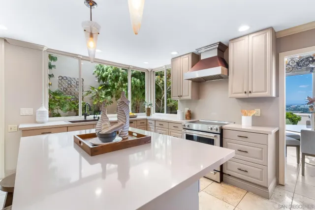 a kitchen with kitchen island a stove a sink dishwasher and white cabinets with wooden floor