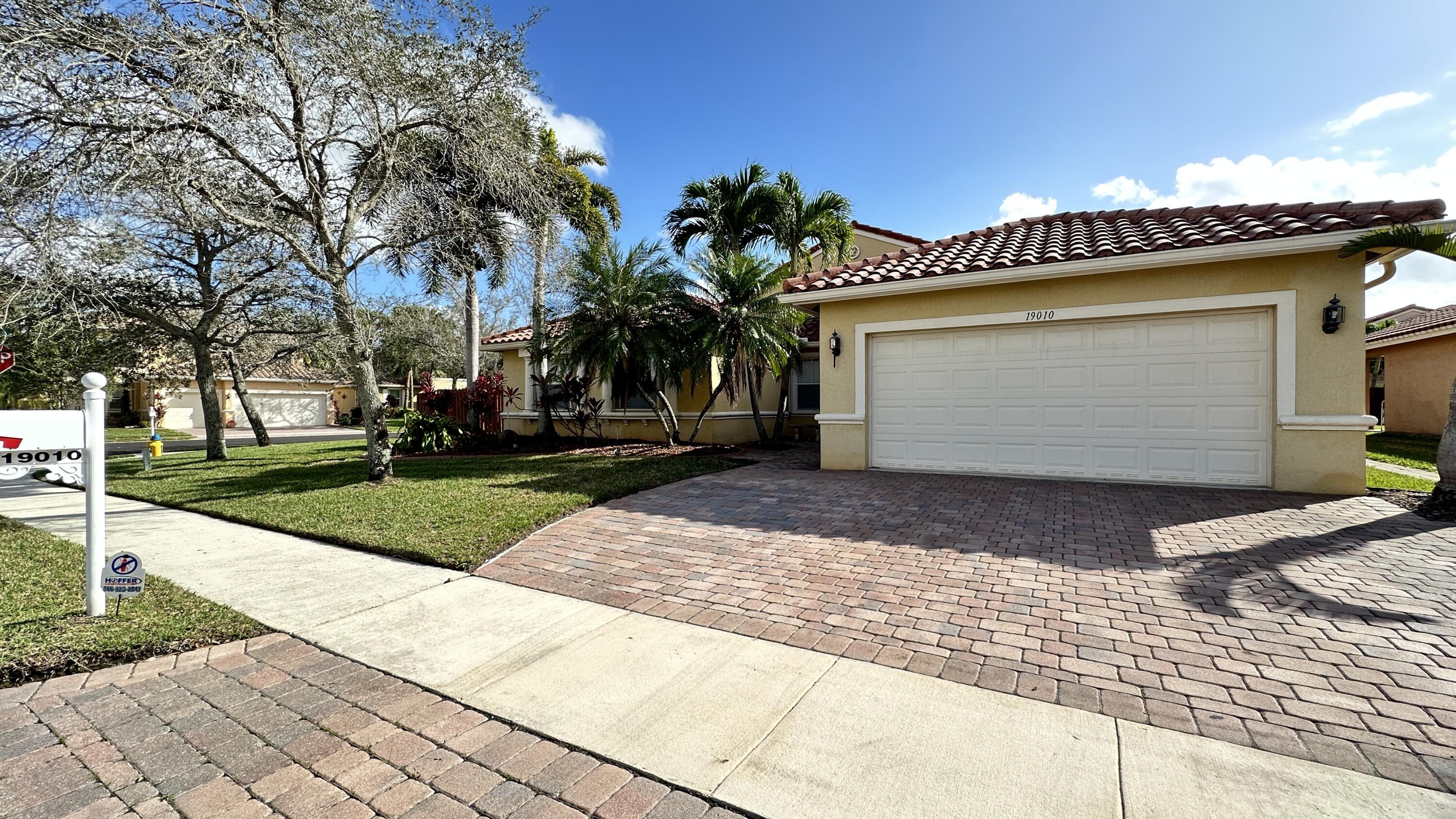19010 Southwest 10th Street Pembroke Pines, FL 33029 - Photo 1 of 59 a front view of a house with a garden and a garage