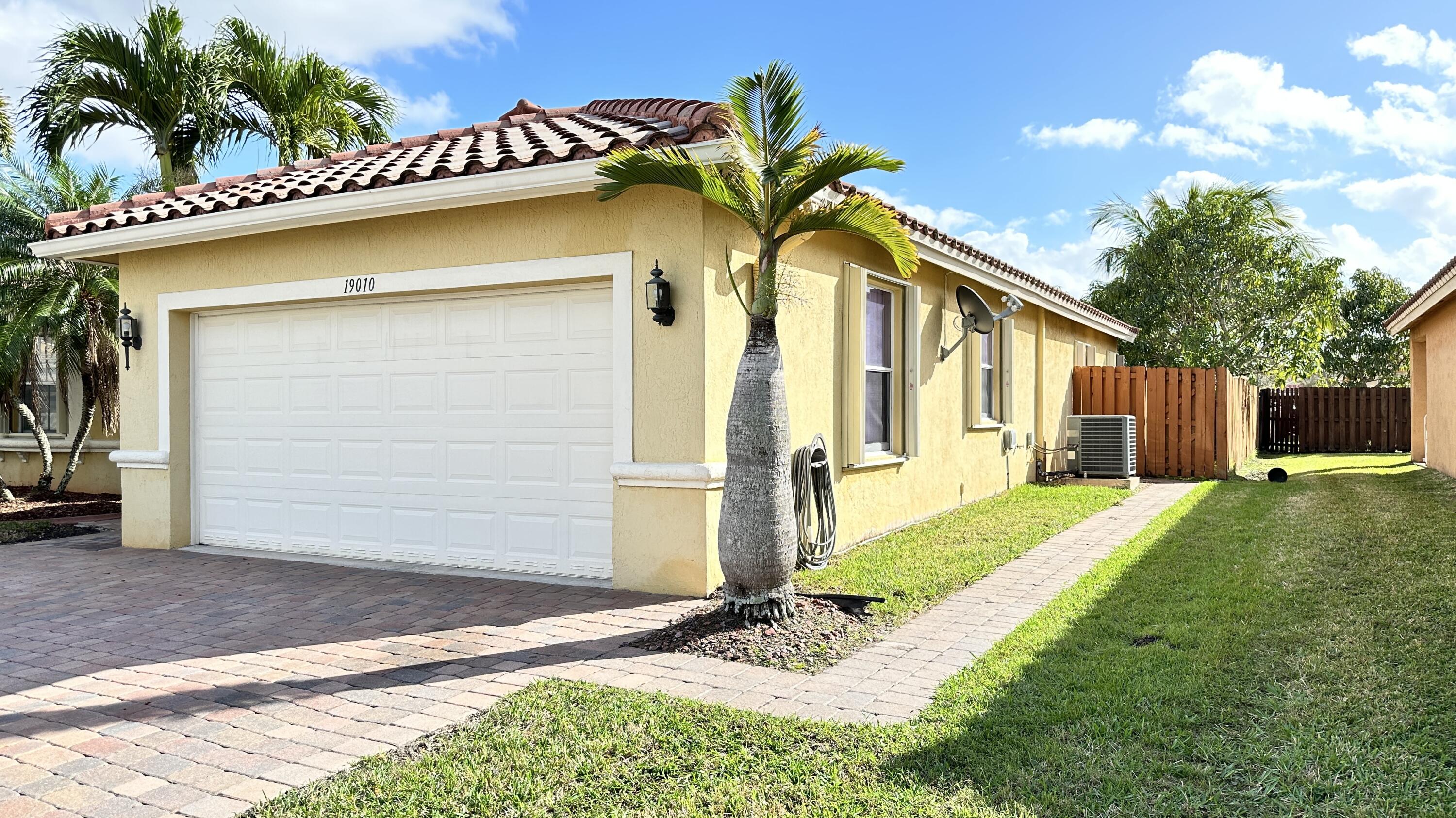 19010 Southwest 10th Street Pembroke Pines, FL 33029 - Photo 2 of 59 a yellow house with trees in front of it