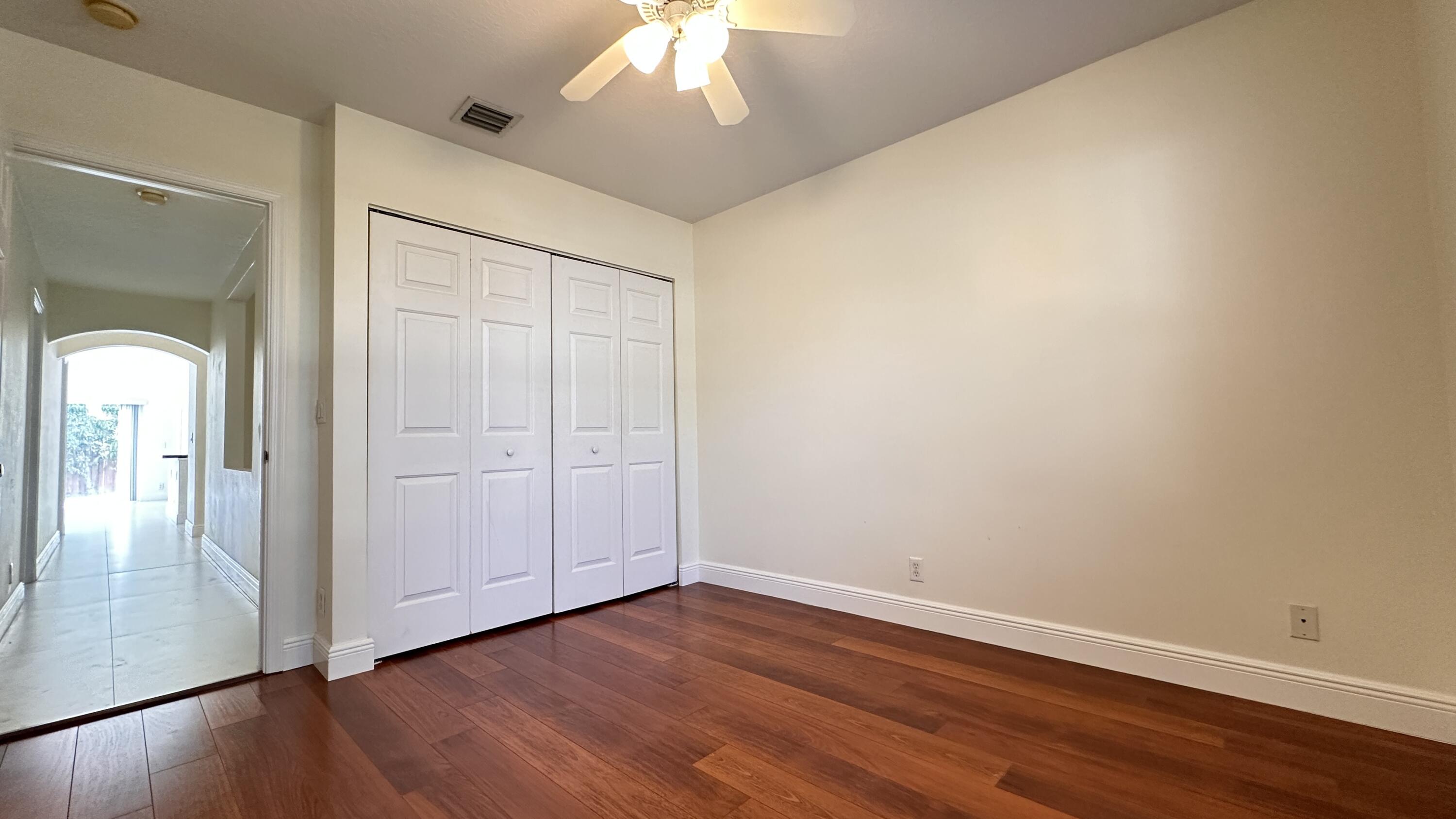 19010 Southwest 10th Street Pembroke Pines, FL 33029 - Photo 26 of 59 an empty room with wooden floor chandelier fan and windows