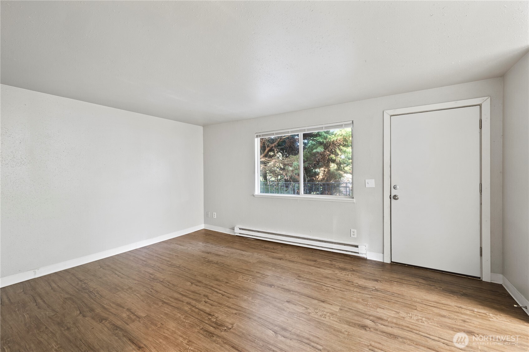 4809 South 252nd Place Kent, WA 98032 - Photo 2 of 5 an empty room with wooden floor and windows