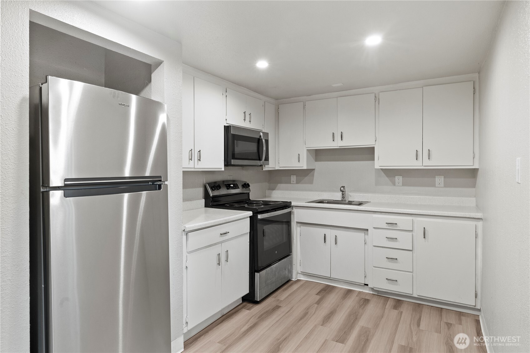 4809 South 252nd Place Kent, WA 98032 - Photo 5 of 5 a kitchen with white cabinets stainless steel appliances and a refrigerator