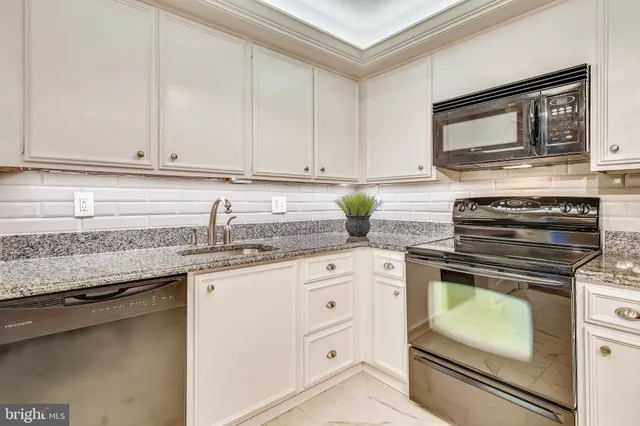 a kitchen with stainless steel appliances granite countertop a refrigerator stove and sink