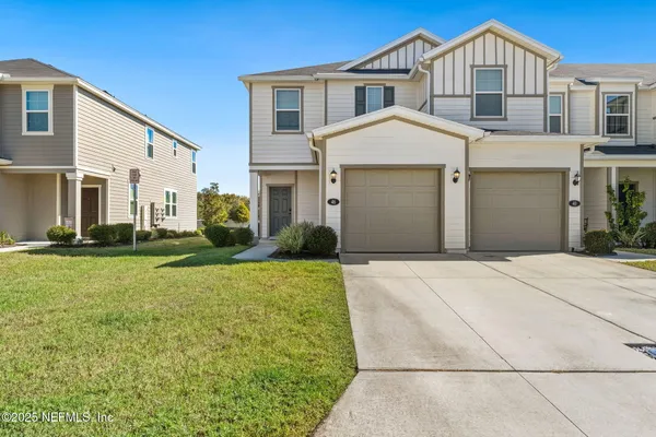 a front view of a house with a yard and garage