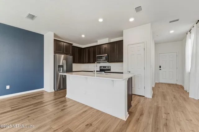 a view of kitchen with stainless steel appliances granite countertop refrigerator oven a sink dishwasher and a refrigerator with wooden floor