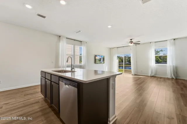 a kitchen with a sink and wooden floor