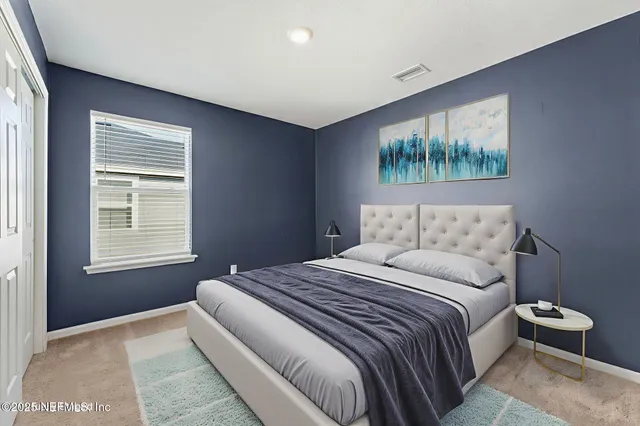 a bedroom with a bed and a painting on the wall