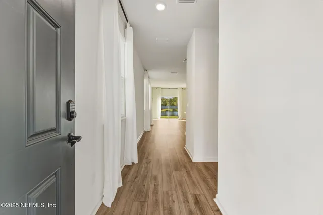 a view of a hallway with wooden floor and staircase