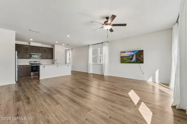 a view of a kitchen with a sink stove cabinets and empty room