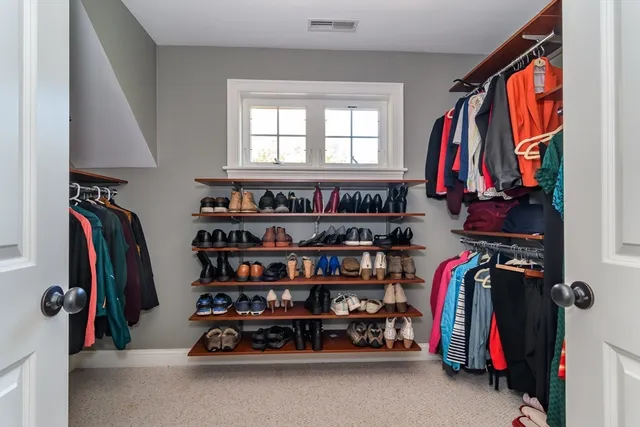 a view of walk in closet with clothes and shoes