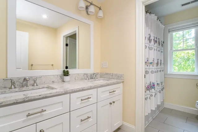 a bathroom with a granite countertop sink a mirror and a shower