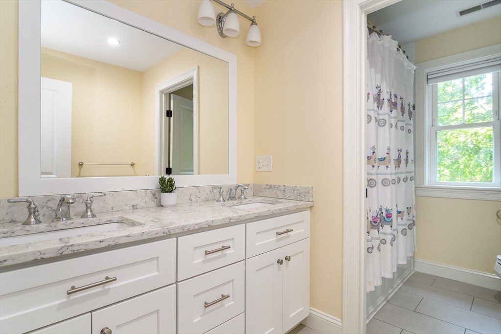 11 Leighton Street Natick, MA 01760 - Photo 22 of 27 a bathroom with a granite countertop sink a mirror and a shower
