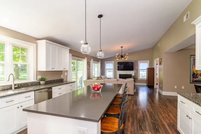 a large kitchen with kitchen island white cabinets and stainless steel appliances