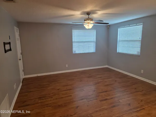 a view of wooden floor and windows in a room