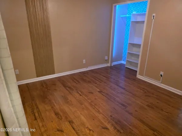a view of an empty room with wooden floor