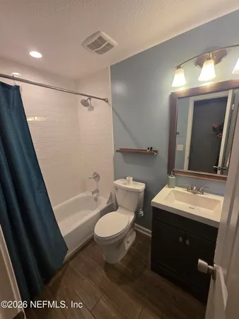 a bathroom with a sink toilet a mirror and bathtub