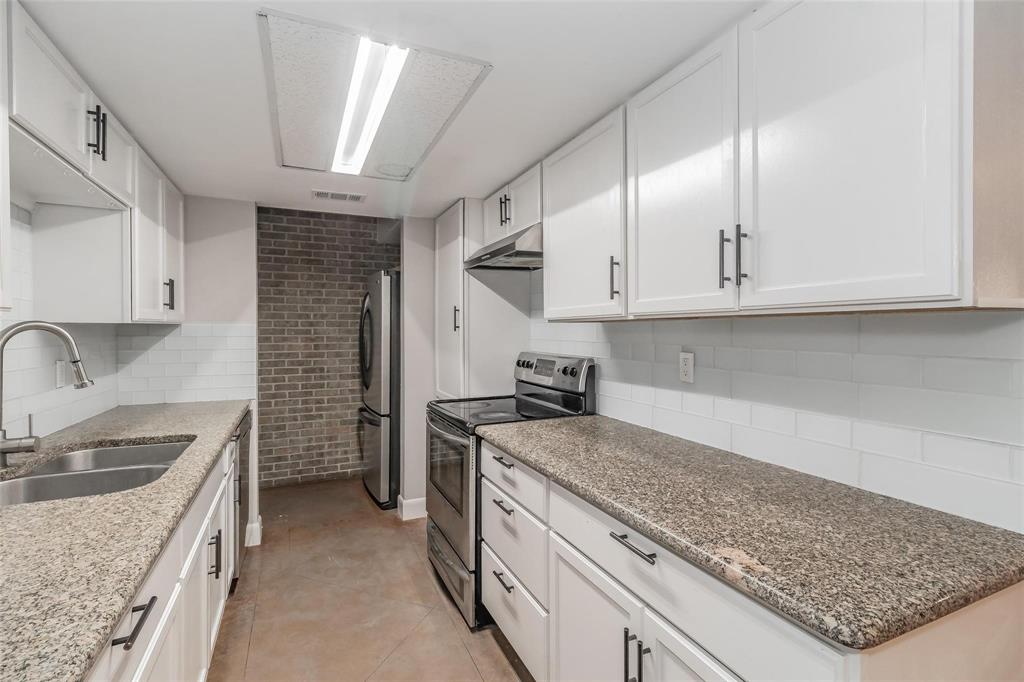 4930 Thunder Road Dallas, TX 75244 - Photo 14 of 23 Kitchen featuring white cabinetry, granite countertops, a stainless steel double sink, and a subway tile backsplash