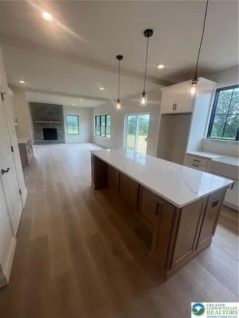a kitchen with kitchen island a sink dishwasher a stove a dining table and chairs with wooden floor