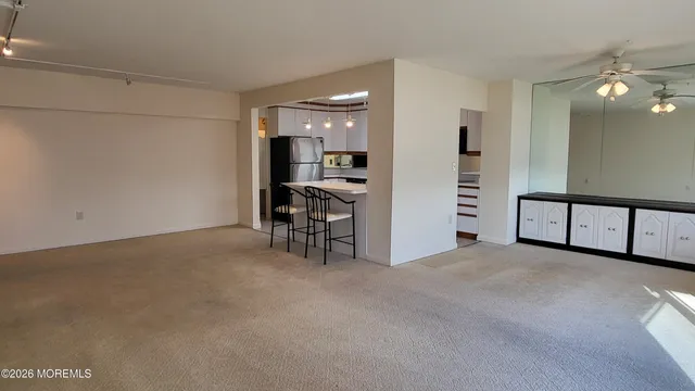 a view of a hallway with wooden floor and a living room