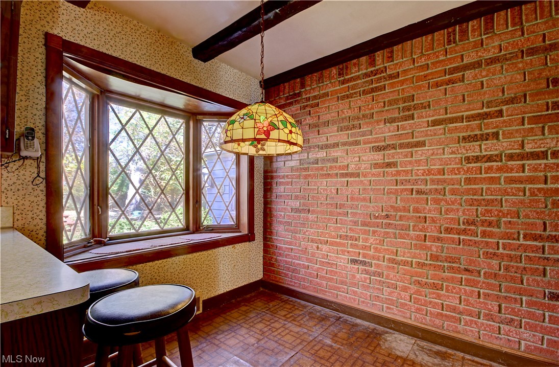 20930 Eaton Road Cleveland, OH 44126 - Photo 14 of 33 Unfurnished dining area with tile flooring, brick wall, plenty of natural light, and beamed ceiling