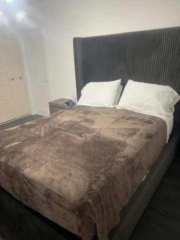 a bed sitting in a bedroom next to a cabinet