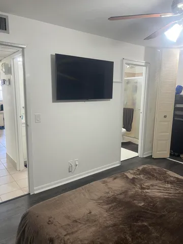 a view of a livingroom with wooden floor and a flat screen tv