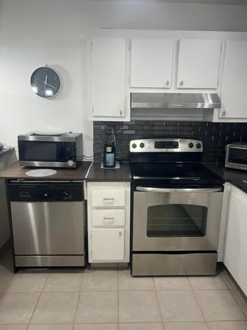 a stove top oven sitting inside of a kitchen