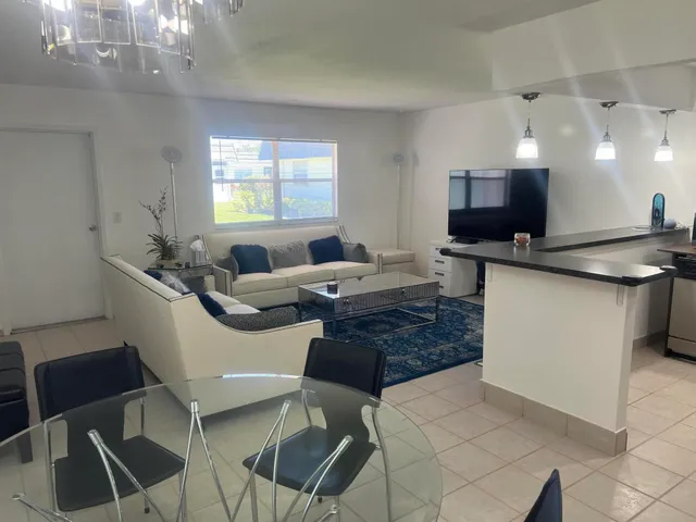 a living room with furniture a large window and a chandelier
