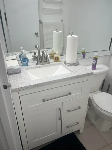 a bathroom with a toilet sink and mirror