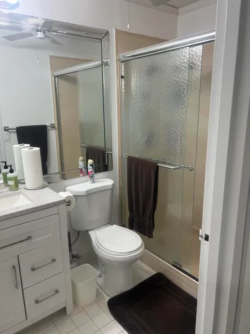 a bathroom with a sink a toilet a mirror and shower